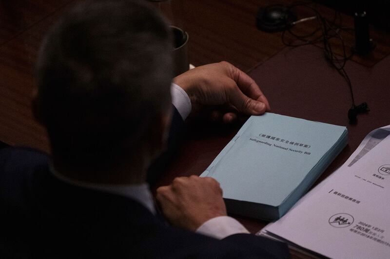 2024年3月19日,香港立法会在二读《基本法》第 23 条立法期间,议员持《维护国家安全法案》副本。(美联社)