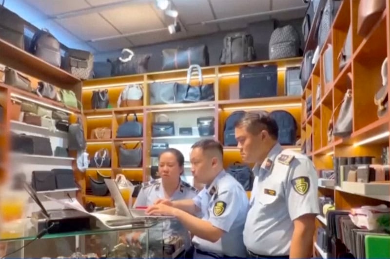 This image made from May 29, 2025 video shows officials checking on counterfeit goods at Saigon Square Mall in Ho Chi Minh City, Vietnam.