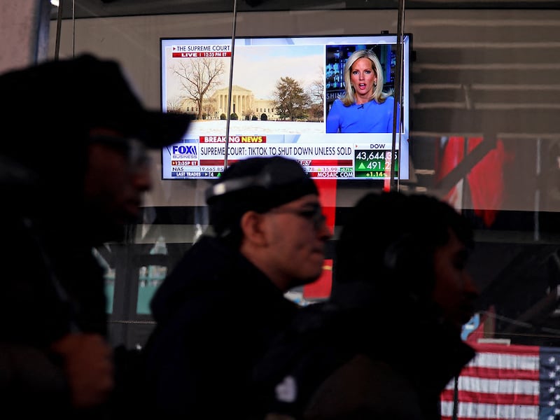 People walk past a television displaying a news broadcast about TikTok near Times Square in New York City, Jan. 17, 2025.