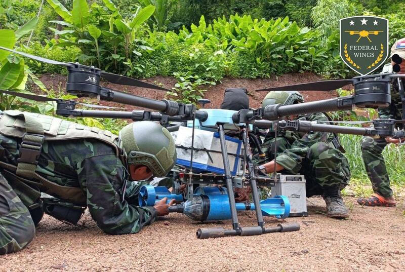Members of Federal Wings, a drone team fighting along with ethnic militias and local People's Defense Force groups, attach two munitions to a drone in this undated photo. Credit: Federal Wings