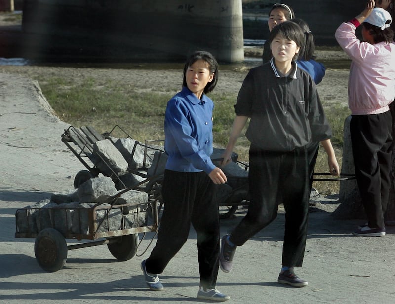 This Oct. 20, 2004, photo shows North Korean students carrying stones to a railway construction site in Kaesong, North Korea.