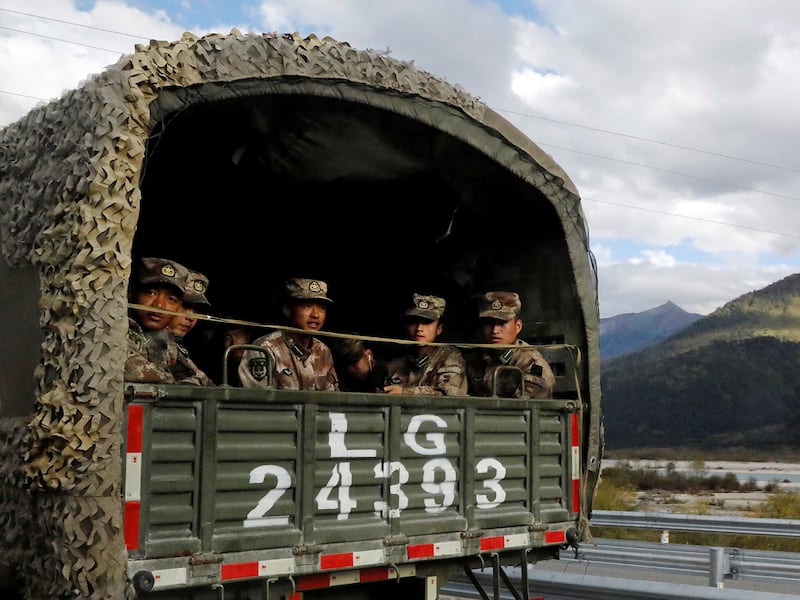 Chinese soldiers of the People's Liberation Army sit on the back of a truck on the highway to Nyingchi, Tibet Autonomous Region, China, Oct. 19, 2020.