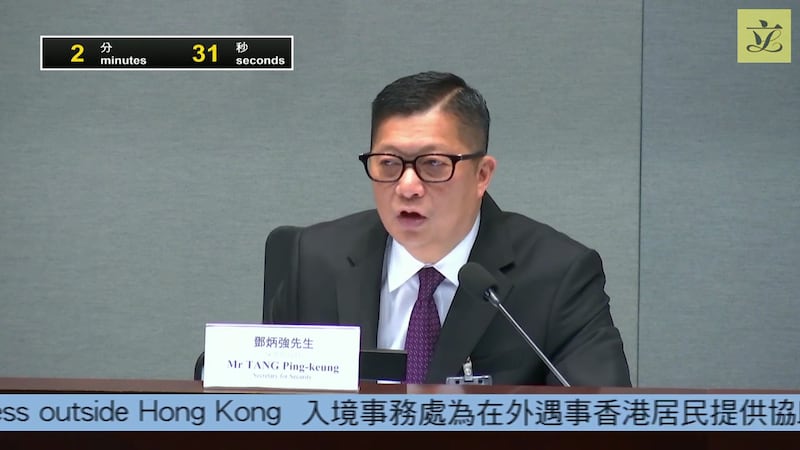 保安局長鄧炳強指,截至11月底共接獲23宗求助,有12宗仍能與外界聯絡,目前只有11人已回港。(立法會直播截圖)